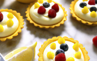 Lemon Curd Tartlets bite-sized tartlets filled with a tangy lemon curd made from fresh lemon juice and zest, topped with whipped cream and fresh berries.