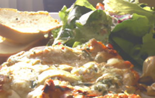 Oven-baked chicken parmesan with a side of garlic bread and a mixed green salad.