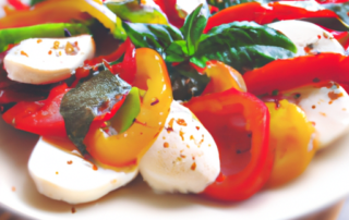 Caprese salad with sliced sweet bell peppers, fresh mozzarella, cherry tomatoes, basil, and a balsamic glaze.